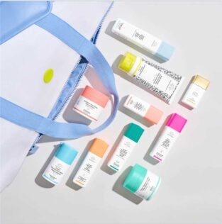 Drunk Elephant travel set featuring branded airless jar, skincare tube, and square airless bottles.